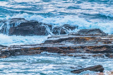 Sydney, NSW, Avustralya 'nın kuzey sahillerindeki Avalon' da kayalar ve dalgalarla kaplı Sunrise Seascape bulutları.