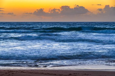 Sydney, NSW, Avustralya 'nın kuzey sahillerindeki Avalon' da kayalar ve dalgalarla gün doğumu.