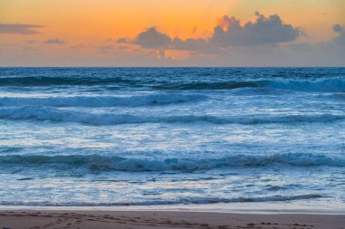Sydney, NSW, Avustralya 'nın kuzey sahillerindeki Avalon' da kayalar ve dalgalarla gün doğumu.