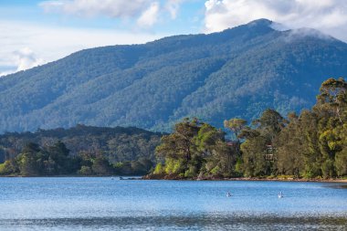 Akşamın erken saatlerinde Wallaga Gölü ve Gulaga Dağı 'nda gün batımı yaklaşırken manzara görülüyor. Avustralya, NSW 'nin Sapphire Sahili' nde Bermagui.