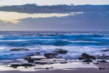 Sydney, NSW, Avustralya 'nın kuzey sahillerindeki Avalon' da kayalar ve dalgalarla gün doğumu.