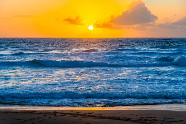 Sydney, NSW, Avustralya 'nın kuzey sahillerindeki Avalon' da kayalar ve dalgalarla gün doğumu.