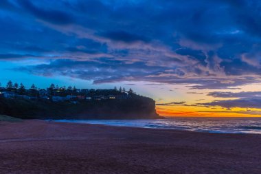 Sydney, NSW, Avustralya 'nın kuzey sahillerindeki Bilgola Plajı' nda yağmur bulutlarıyla Sunrise Seascape.