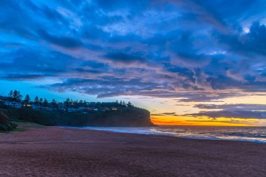Sydney, NSW, Avustralya 'nın kuzey sahillerindeki Bilgola Plajı' nda yağmur bulutlarıyla Sunrise Seascape.