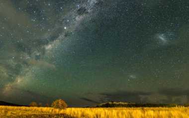 Samanyolu 'nun gece gökyüzü Blayney, Orta Batı, NSW, Avustralya' da yıldızlar ve ışık bulutlarıyla doluydu..
