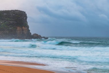 Sydney, NSW ve Avustralya 'nın kuzey sahillerinde Avalon' da yağmur bulutlarıyla sörf yapmak..