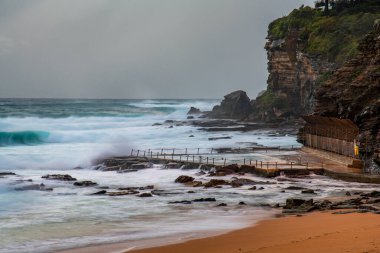 Sydney, NSW ve Avustralya 'nın kuzey sahillerinde Avalon' da yağmur bulutlarıyla sörf yapmak..