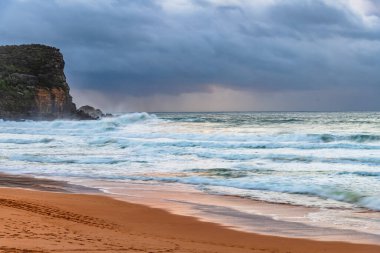Sydney, NSW ve Avustralya 'nın kuzey sahillerinde Avalon' da yağmur bulutlarıyla sörf yapmak..