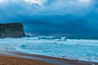 Sydney, NSW ve Avustralya 'nın kuzey sahillerinde Avalon' da yağmur bulutlarıyla sörf yapmak..