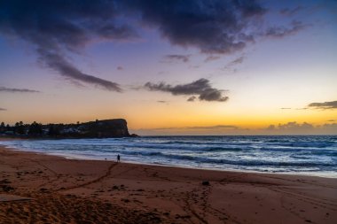 Sydney, NSW, Avustralya 'nın kuzey sahillerindeki Avalon' da kayalar ve dalgalarla gün doğumu.
