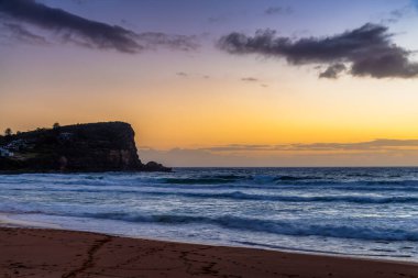 Sydney, NSW, Avustralya 'nın kuzey sahillerindeki Avalon' da kayalar ve dalgalarla gün doğumu.