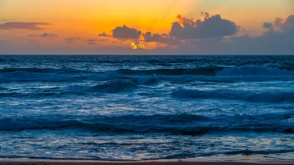 Sydney, NSW, Avustralya 'nın kuzey sahillerindeki Avalon' da kayalar ve dalgalarla gün doğumu.