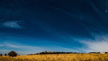 Gece gökyüzü yıldızlarla doluydu ve Blayney, Orta Batı, NSW, Avustralya kırsal bölgelerde hafif bulutlar vardı..