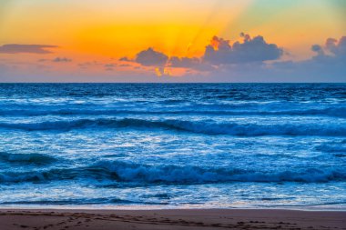 Sydney, NSW, Avustralya 'nın kuzey sahillerindeki Avalon' da kayalar ve dalgalarla gün doğumu.