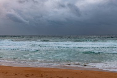 Sydney, NSW ve Avustralya 'nın kuzey sahillerinde Avalon' da yağmur bulutlarıyla sörf yapmak..