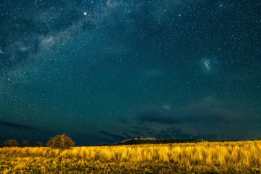 Samanyolu 'nun gece gökyüzü Blayney, Orta Batı, NSW, Avustralya' da yıldızlar ve ışık bulutlarıyla doluydu..