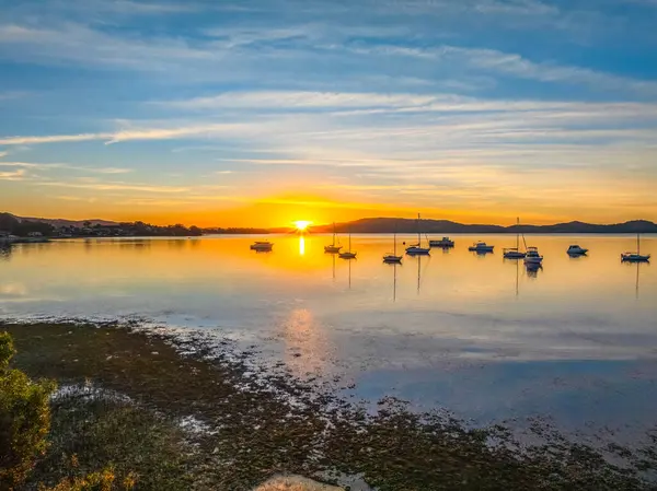 NSW, Avustralya 'nın merkez sahillerinde Brisbane Su ve Koolewong üzerinde bulutlu ve tekneli hava gündoğumu.