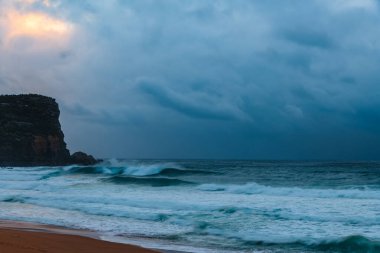 Sydney, NSW ve Avustralya 'nın kuzey sahillerinde Avalon' da yağmur bulutlarıyla sörf yapmak..