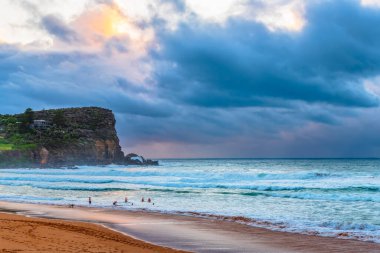 Sydney, NSW ve Avustralya 'nın kuzey sahillerinde Avalon' da yağmur bulutlarıyla sörf yapmak..