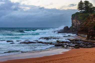 Sydney, NSW ve Avustralya 'nın kuzey sahillerinde Avalon' da yağmur bulutlarıyla sörf yapmak..