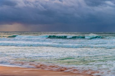 Sydney, NSW ve Avustralya 'nın kuzey sahillerinde Avalon' da yağmur bulutlarıyla sörf yapmak..