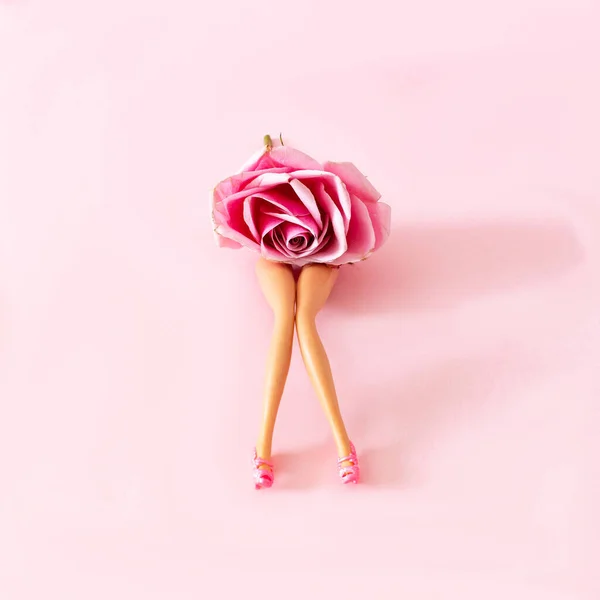 Stock image Women legs with high heels and a pink rose head on pastel pink background. Minimal surreal concept for fashion trend editorial. Provocative sexy design.