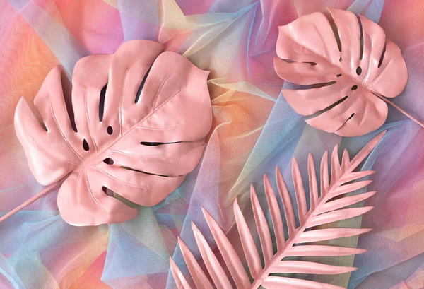 İki pastel pembe egzotik yaprak ve şeffaf renkli kumaş üzerinde bir palmiye yaprağı. Yaz tatili ilanı, kart ya da afiş için gerçeküstü arka plan ya da duvar kağıdı. Düz yatıyordu.