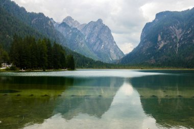 Meravigliosa vista panoramica del lago di Dobbiaco in una giornata nuvolosa d'estate, con i suoi idilliaci riflessi, Alpi italiane, Val Pusteria, Sud Tirolo, Italia.