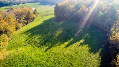 Aerial landscape of colorfull wood and meadows in Appennini mountains close to Modena city in Italy during a sunny autumnal day clipart