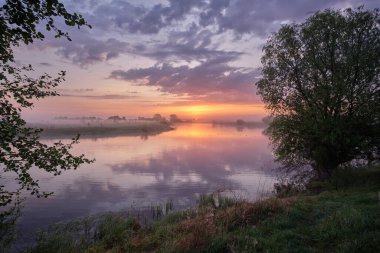 Gölün üzerinde puslu bir şafak.
