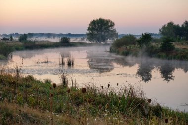 Gölün üzerinde puslu şafak.