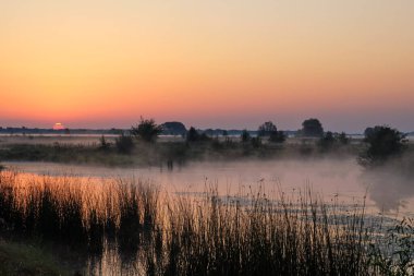 Gölün üzerinde puslu şafak.