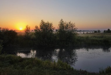 Gölün üzerinde puslu şafak.
