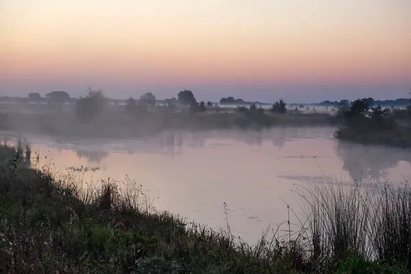 Gölün üzerinde puslu şafak.