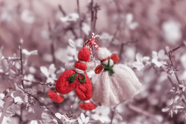 Spring beginning symbol - Martenitsa on blossoming tree. Decorations made of red and white thread are presented in Bulgaria on 1st of March holiday. Spring background with garden tree flowers bloom