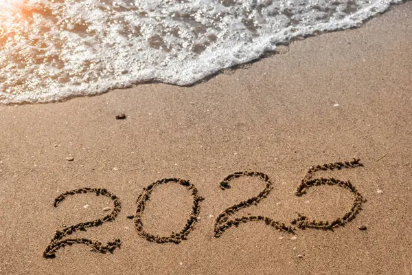 Plajın altın kumu ve dalgalanan deniz dalgasında 2025 numara. 2025 yılınız kutlu olsun. Yeni yıl tatili için deniz kıyısındaki tatil köyünde sıcak bir yer. Seyahat, değişim, yeni başlangıç, vizyon kavramı