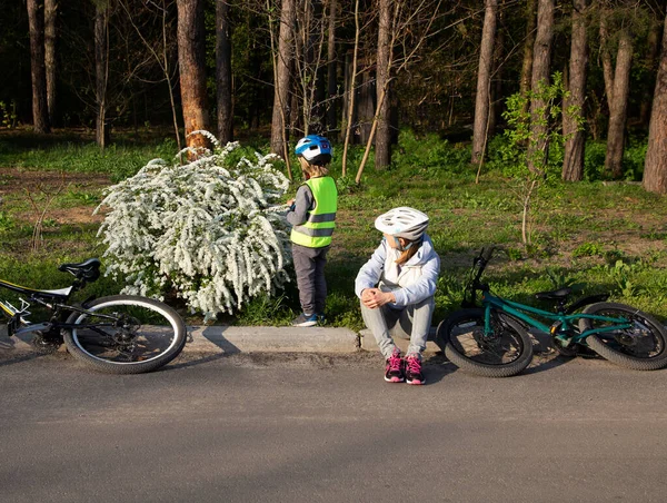 mom with a little son in helmets ride bicycles on a spring sunny day. Healthy lifestyle. active holidays with family. Woman with a child in nature with bicycles