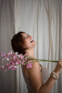 happy, beautiful woman in profile, laughing joyfully, a blooming spring twig on her shoulder. elegant business woman celebrating triumph, good news. Positive thinking