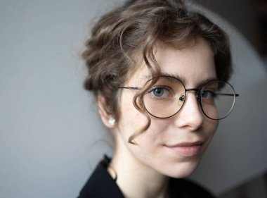 Kendine güvenen bir genç kızın portresi. 18 yaşında, öğrenci, kameraya bakan bir üniversite öğrencisi. Gözlüklü genç ve zeki bir kadın. Seçici odak, boşluğu kopyala