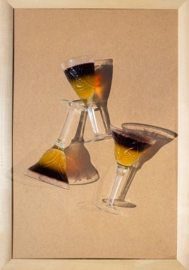 Lezzetli yaz renklendirici jöleli tatlılar. Üç kristal şarap kadehi, iki renkli donmuş jöle, bej arka planda, üst manzaralı. İlginç zıt gölgeler. Neşeli ve eğlenceli bir ortam.