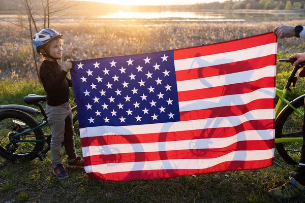 日落时分 两辆自行车在明亮的美国大旗后面的轮廓线 美利坚合众国独立日 骑自行车 到城外度假 — 图库照片