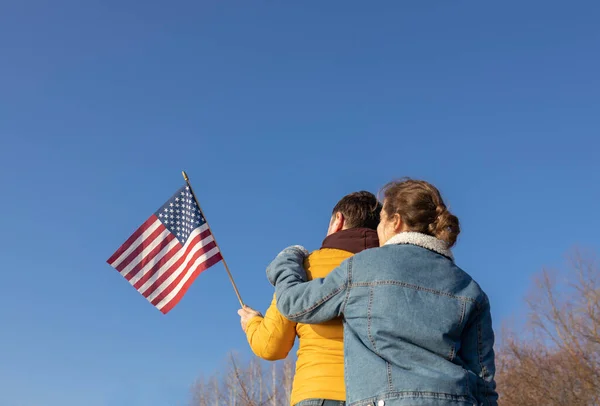 难以辨认的男男女女背对着蓝天站在一起 举着美国国旗 民族特性 美利坚合众国独立日 — 图库照片