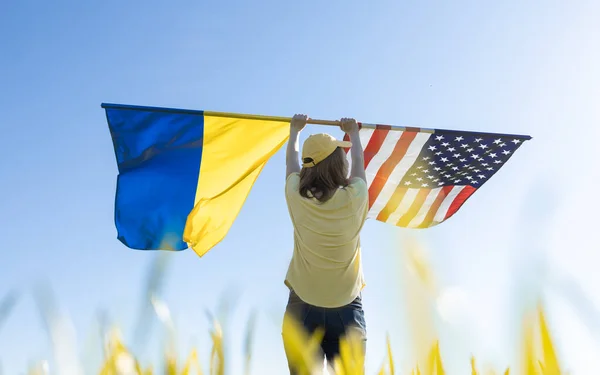 Жінка Сонячний День Стоїть Спиною Піднімає Два Великих Прапори Американський — стокове фото