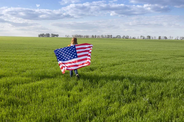 在绿地中快乐的女孩背着美国国旗 独立日 美利坚合众国自由的国家象征 爱国假日 成为美国人的骄傲 — 图库照片