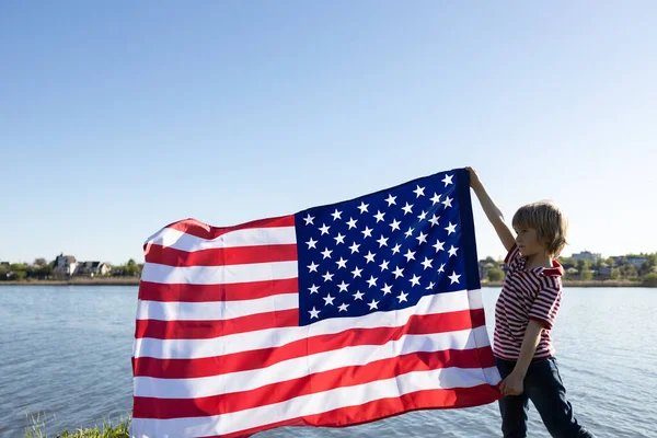 在阳光明媚的日子 孩子们在湖上举着一面美国的大旗 独立日 美利坚合众国自由和独立的国家象征 成为美国人的骄傲 — 图库照片