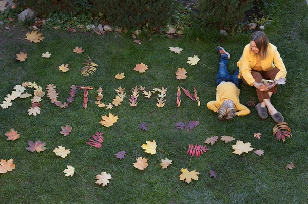 Jesienny Dzień Mama Syn Siedzą Trawie Obok Nich Liści Wyłożone — Zdjęcie stockowe