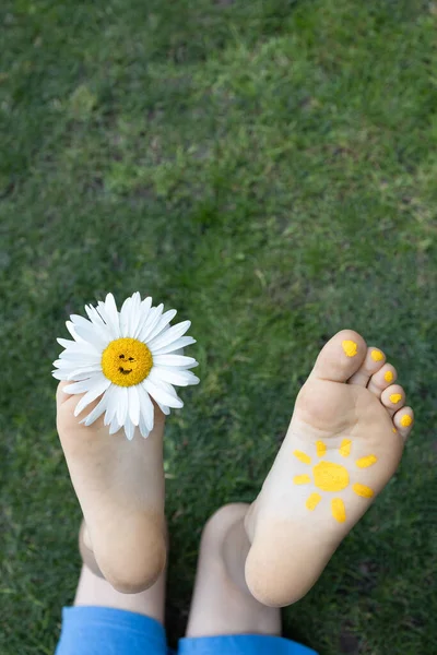 Kwiat Rumianku Między Palcami Gołej Stopy Pomalowanym Słońcem Innej Stopie — Zdjęcie stockowe