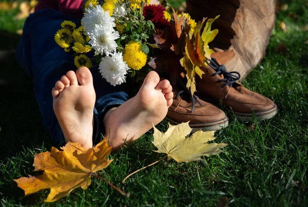 Голі Ноги Дитини Лежать Траві Поруч Букетом Осіннього Листя Коричневому — стокове фото