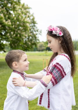7 yaşında bir kız ve 4 yaşında bir oğlan, erkek kardeş, kız kardeş, karşı karşıya durun, birbirlerinin ellerini tutun. Çocuklar işlemeli Ukrayna giysileri giyerler. Aile, savaş sırasında destek. Bağımsızlık Günü