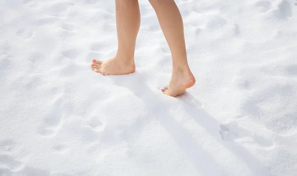 Beautiful women's feet walk barefoot on freshly fallen snow. Healthy lifestyle concept. Temper yourself in the cold season, increase immunity in the winter season. Love Winter